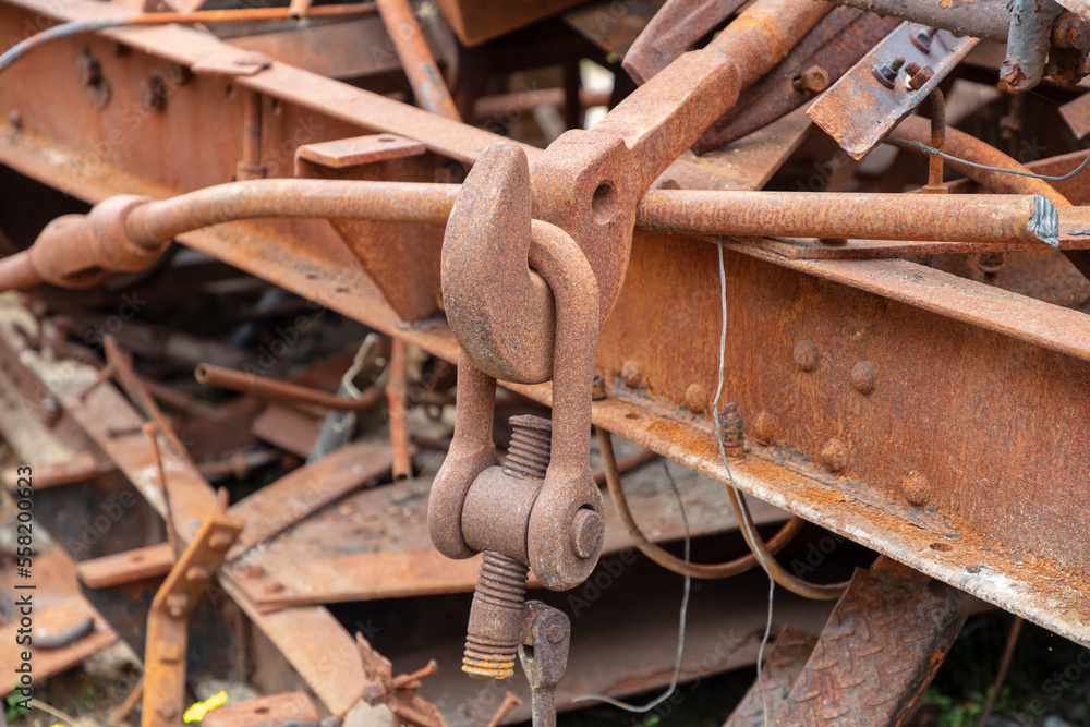 Photograph of old and rusty heavy duty metal hook attached to a large D-Bolt at the end of an unused and scrapped rail carriage