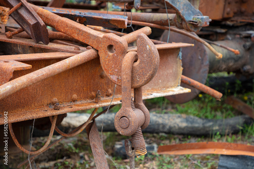 Photograph of old and rusty heavy duty metal hook attached to a large D-Bolt at the end of an unused and scrapped rail carriage
