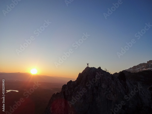 the success of the man on the rocks at sunrise and enjoying nature