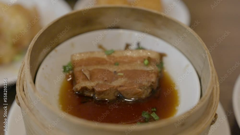 This close up video shows chopstick picking up pork belly with preserved vegetables from a restaurant dish. This close up video shows chopstick picking up pork belly with preserved vegetables from a restaurant dish.