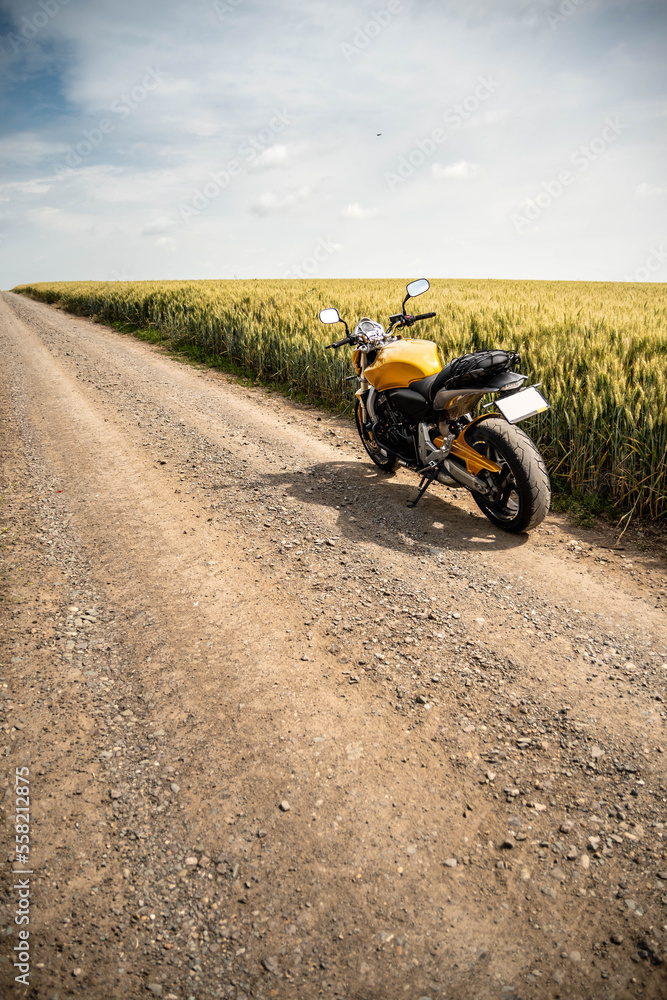 Gravel road with the motorcycle in to a wheat field Gravel road with the motorcycle in to a wheat field