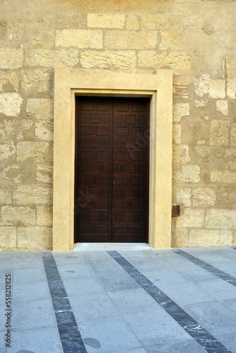 The beautiful exterior facade with a wooden door in the historic of Cordoba Spain © Fernando Batista
