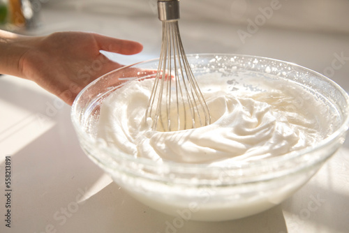 female hands using electric mixer to make whipped cream
