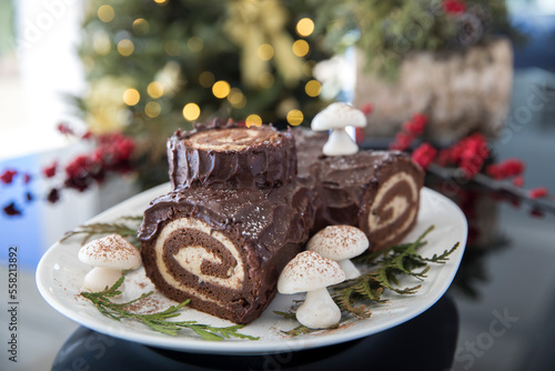 Decorated yule log with christmas tree in the background photo