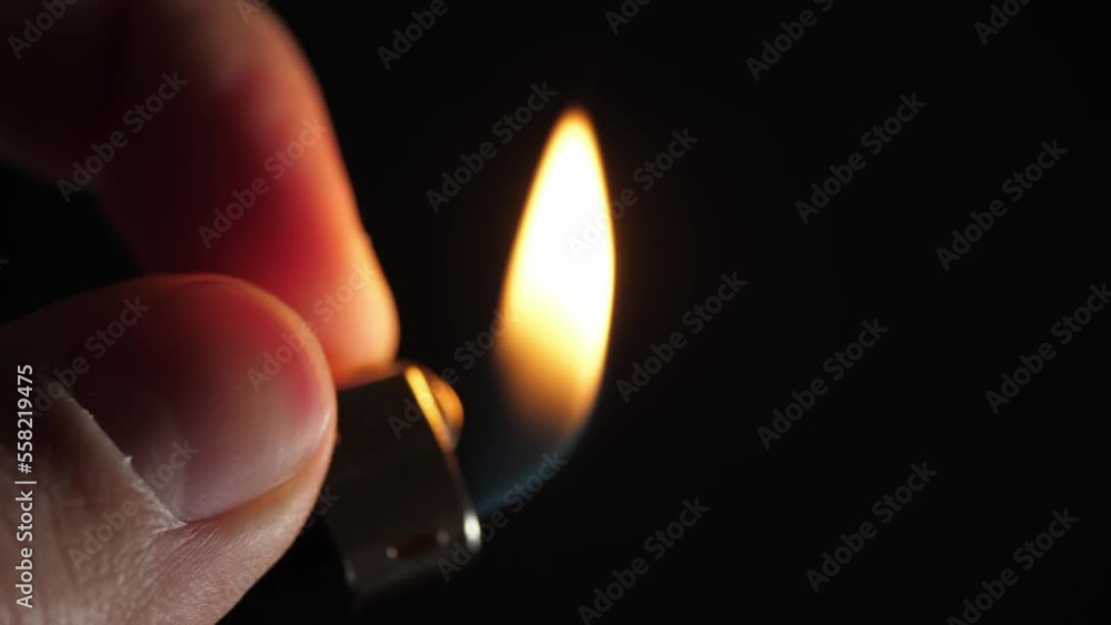 The flame of a lighter. The hand holds the lighter on the left. Close-up. Slow movement. Reverse movement. The flame of a lighter. The hand holds the lighter on the left. Close-up. Slow movement. Reverse movement.
