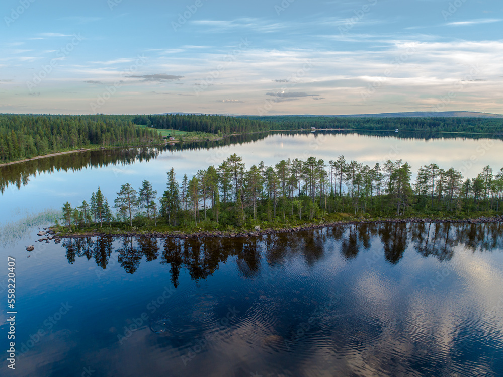Aerial View Small Island in the Sandsjön Lake in Sandsjönäs, Swedish Lappland during Sunset with reflections in the water
