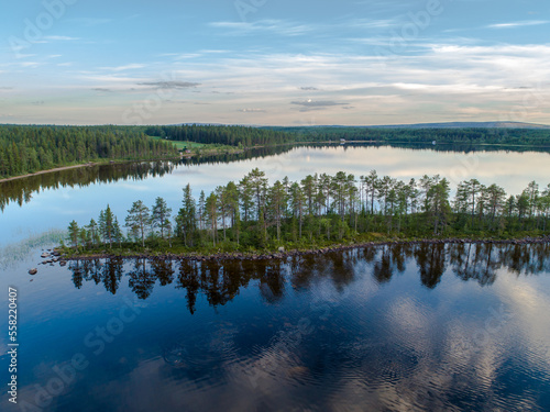 Aerial View Small Island in the Sandsjön Lake in Sandsjönäs, Swedish Lappland during Sunset with reflections in the water