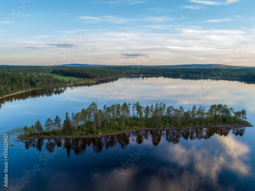 Aerial View Small Island in the Sandsjön Lake in Sandsjönäs, Swedish Lappland during Sunset with reflections in the water