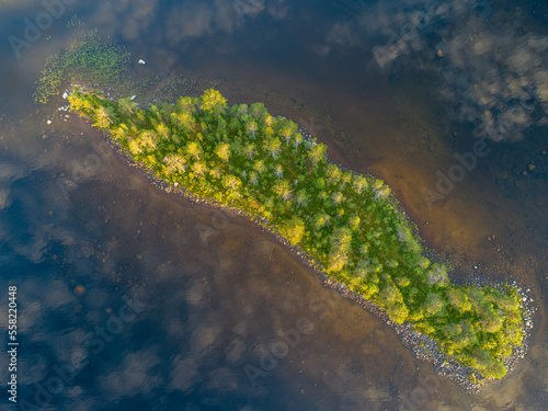 Aerial View Small Island in the Sandsjön Lake in Sandsjönäs, Swedish Lappland during Sunset with reflections in the water