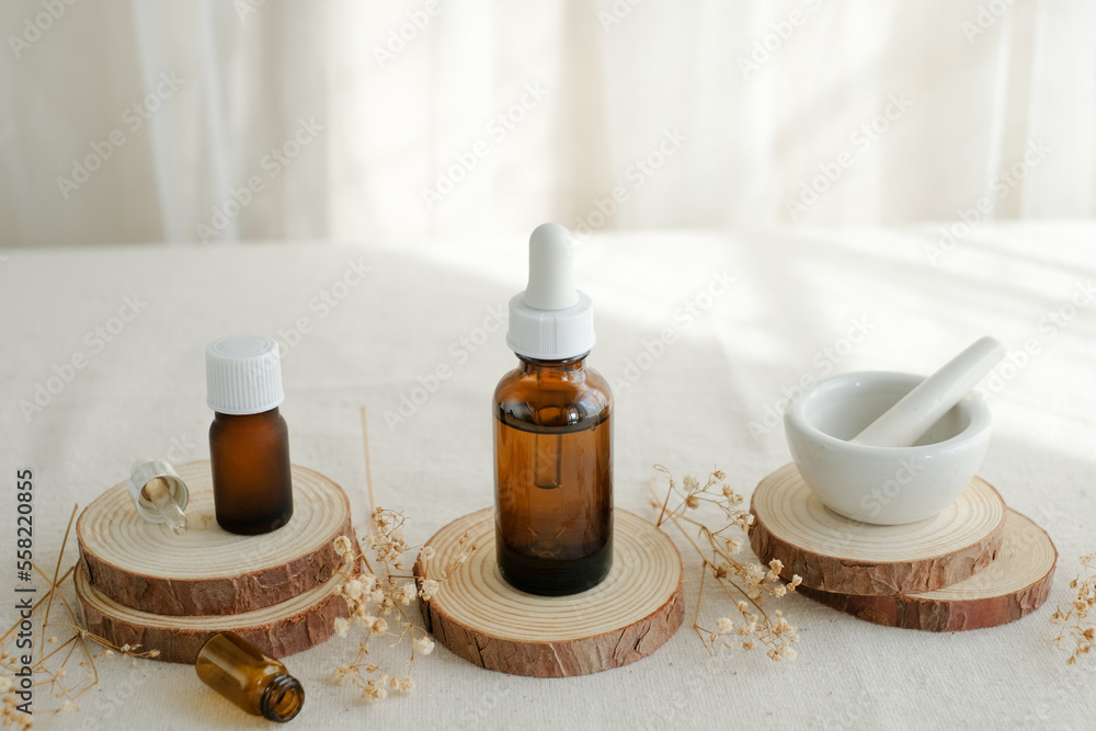 amber glass bottle white, dropper with pestle and mortar on wooden stand and flower. skincare, spa, and beauty product. amber glass bottle white, dropper with pestle and mortar on wooden stand and flower. skincare, spa, and beauty product.