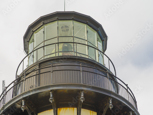 Large lighthouse tower. Close-up. A beautiful majestic building under a cloudy sky. Architecture, construction, navigation, tourism, excursions, travel.