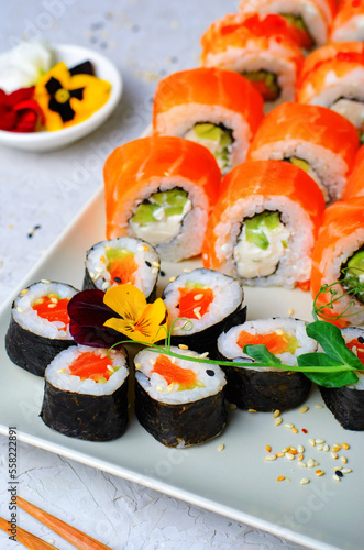 Sushi rolls set with salmon and shrimp on light blue background, Flower Shaped Sushi Rolls, Japanese cuisine