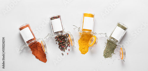 Overturned jars with different spices on light background, top view © Pixel-Shot