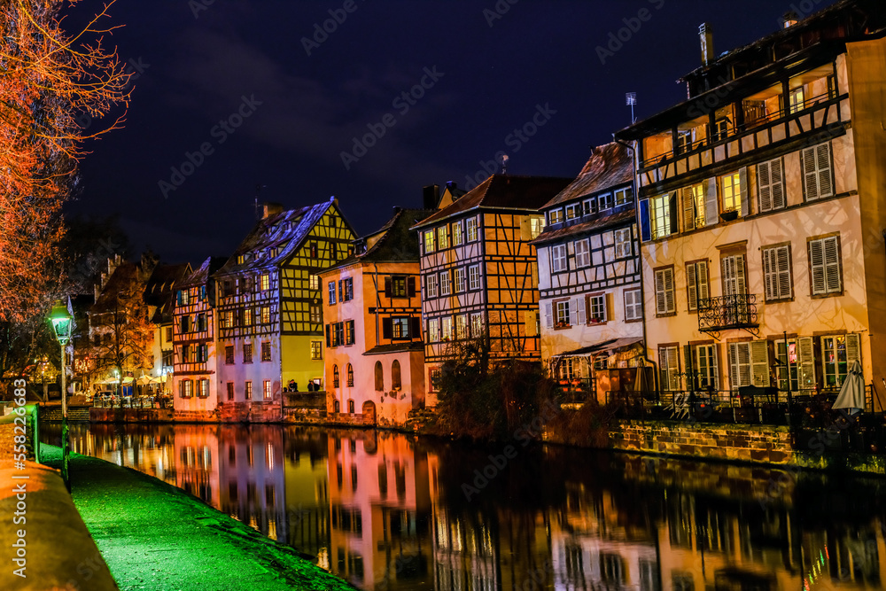 houses reflected in the water of the canal passing through the old quarter of Strasbourg in the evening