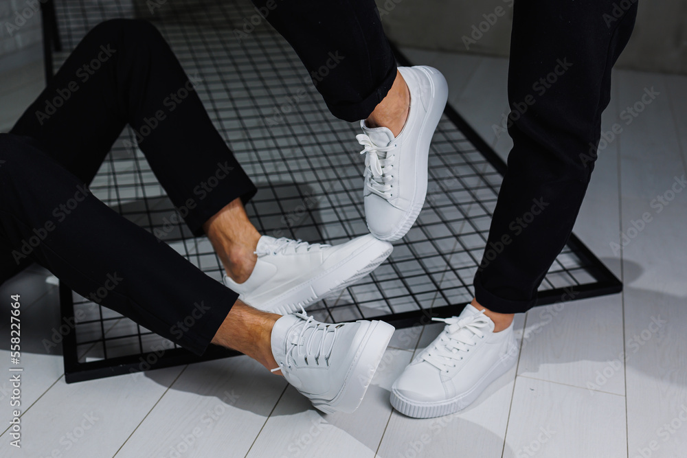 Close up of male and female legs in black pants and white casual sneakers. Summer men s and women s leather shoes Stock Photo Adobe Stock