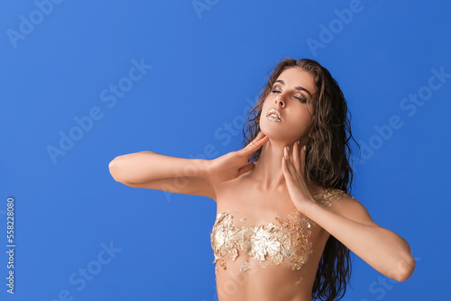 Naked young woman with gold...