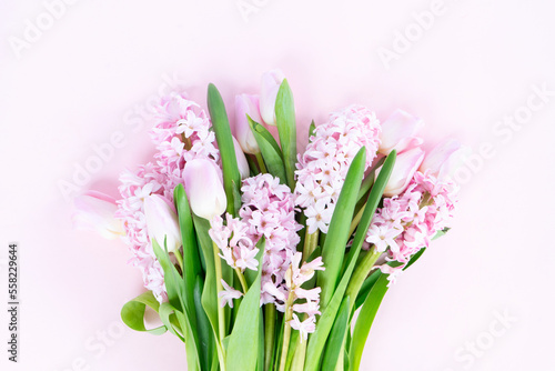 Easter scene with fresh tulips and hyacinth flowers bouquet over pink background