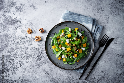 Roasted pumpkin avocado arugula goat cheese salad in a plate