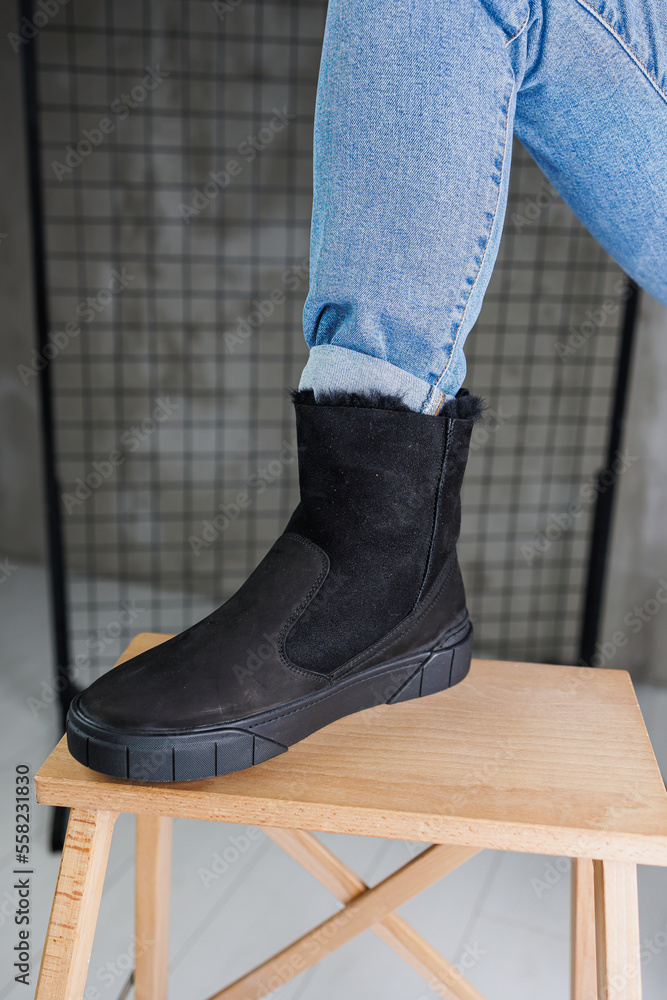 Close-up of male legs in jeans and black winter boots. Men's winter warm leather shoes Close-up of male legs in jeans and black winter boots. Men's winter warm leather shoes