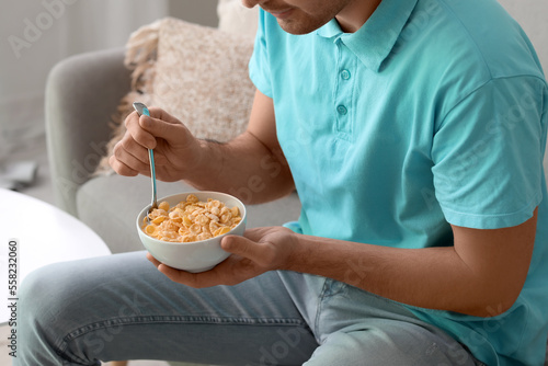 Young man eating cornflakes...