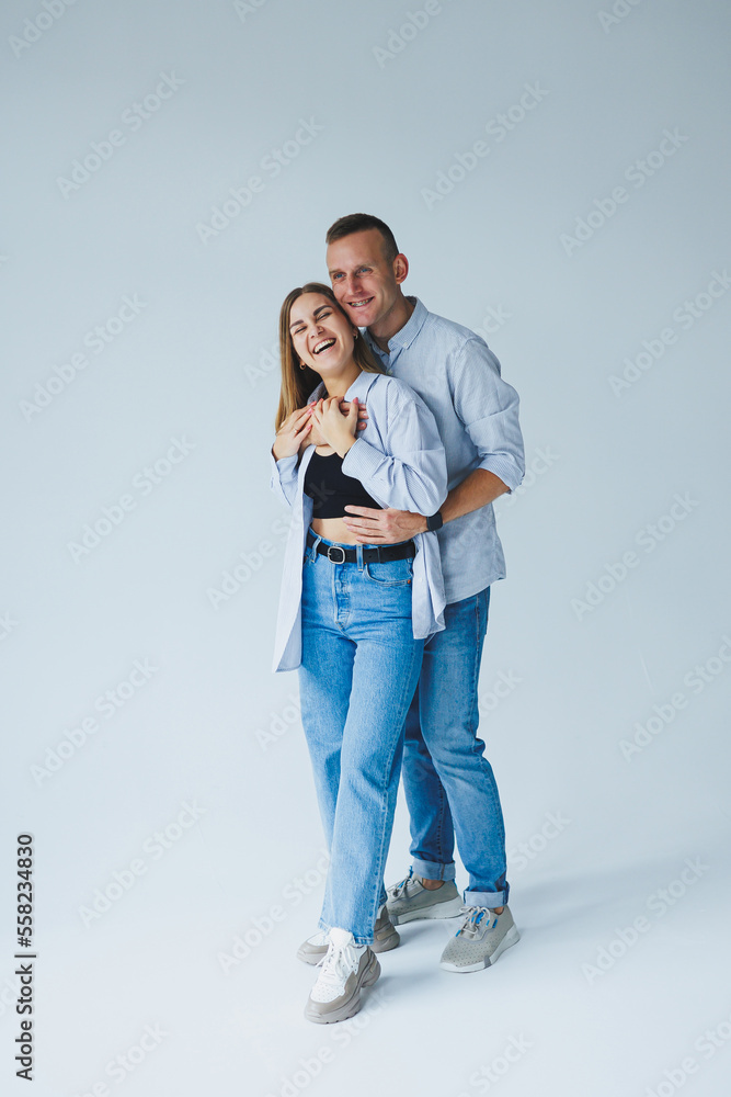Photo of happy couple wearing white shirts, blue jeans, isolated white background. A man and a woman are hugging on a white background Photo of happy couple wearing white shirts, blue jeans, isolated white background. A man and a woman are hugging on a white background