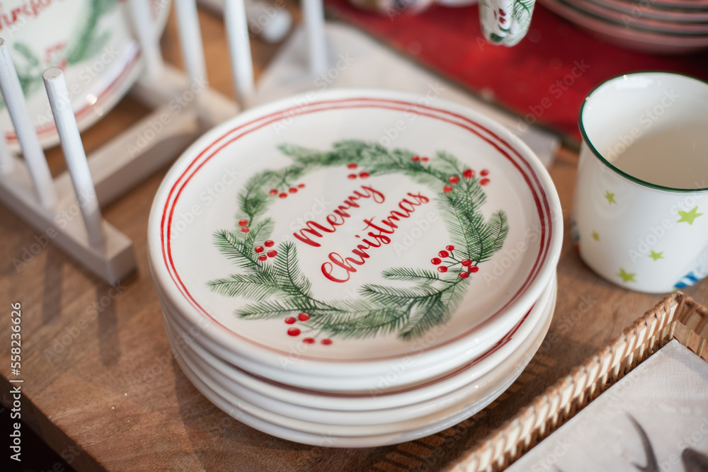 Merry Christmas plates for home decor. Festive tableware or kitchenware in the store for winter holiday shopping. Buying gifts for Xmas. Merry Christmas plates for home decor. Festive tableware or kitchenware in the store for winter holiday shopping. Buying gifts for Xmas.