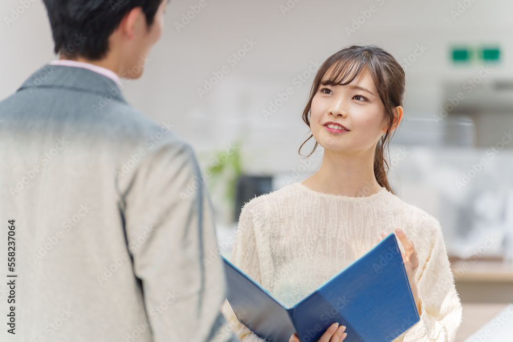 オフィスで立ち話をする若い男女
