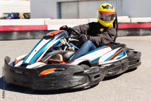 Glad cheerful positive smiling woman driving sport car for karting in a circuit lap outdoor in sport club