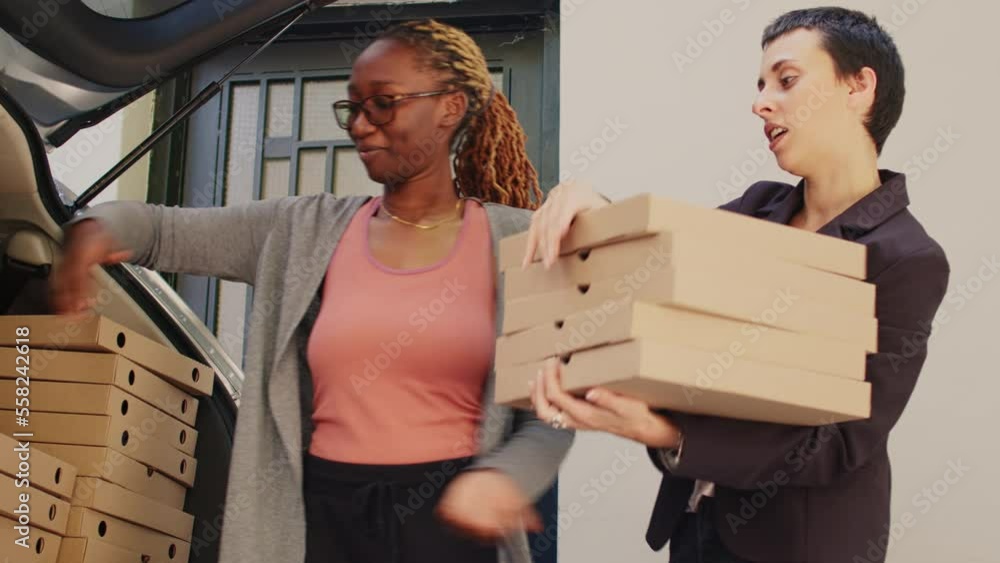 Fastfood restaurant courier delivering huge pizzeria order from car trunk, giving stack of pizza boxes to customer at front door. Food delivery service worker taking meal packages out of vehicle. Fastfood restaurant courier delivering huge pizzeria order from car trunk, giving stack of pizza boxes to customer at front door. Food delivery service worker taking meal packages out of vehicle.