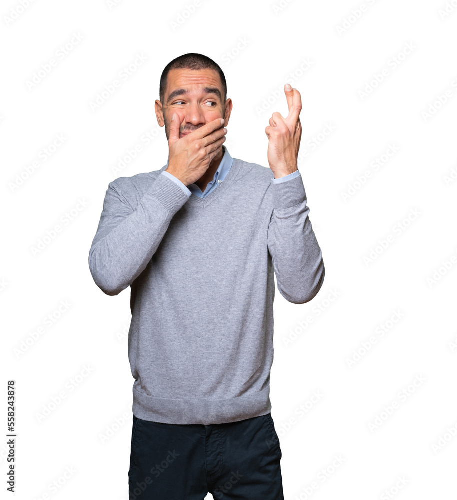 Concerned young man doing a crossed fingers gesture Concerned young man doing a crossed fingers gesture