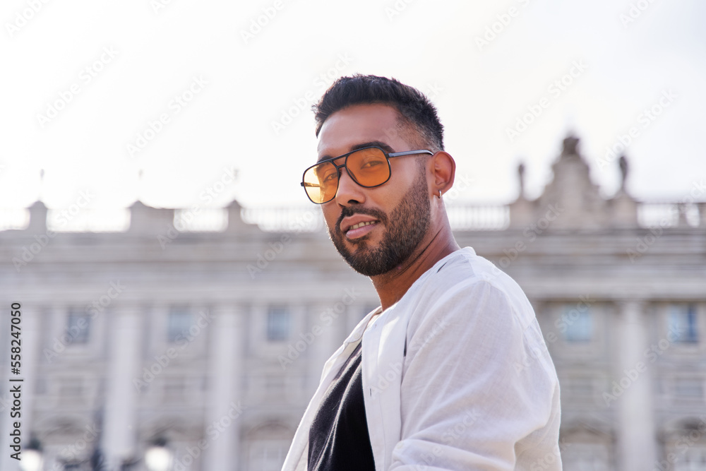 portrait of a latin man posing, serious with city background. man with beard and orange sunglasses looking at camera. portrait of a latin man posing, serious with city background. man with beard and orange sunglasses looking at camera.