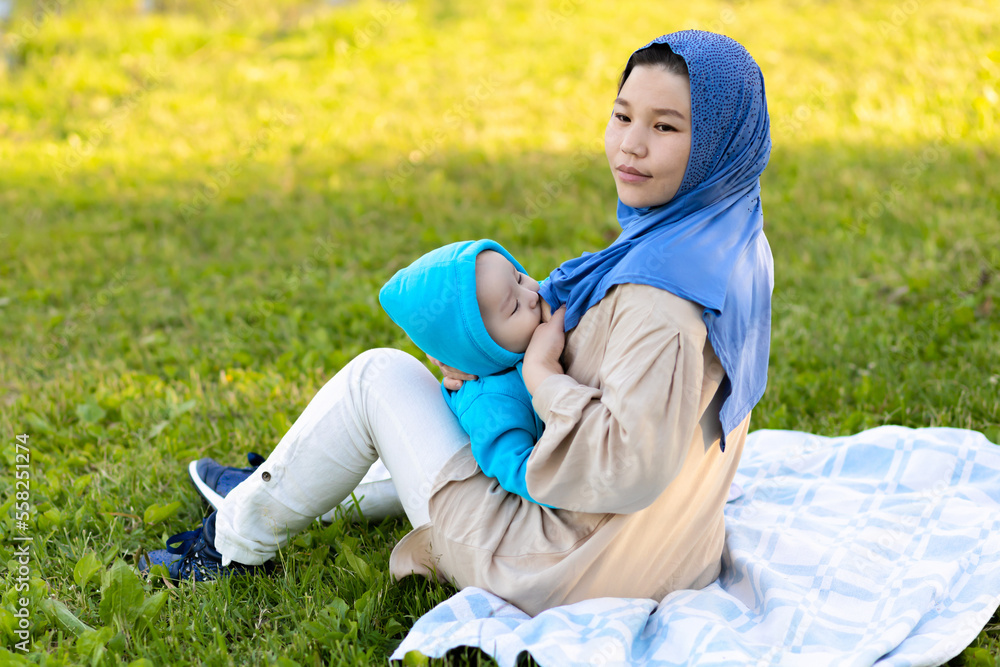 breast feeding concept. young islamic woman hugging newborn baby boy in