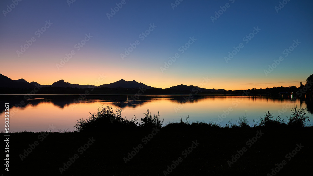 Obraz premium Hopfensee im traumhaften Abendlicht mit Bergsilhouette, Bayern, Deutschland