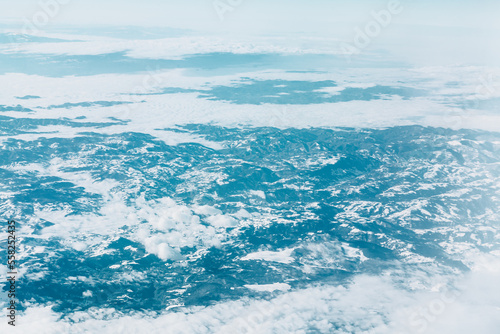 Snowy clouds over snowy mountains . Winter flight scenery 