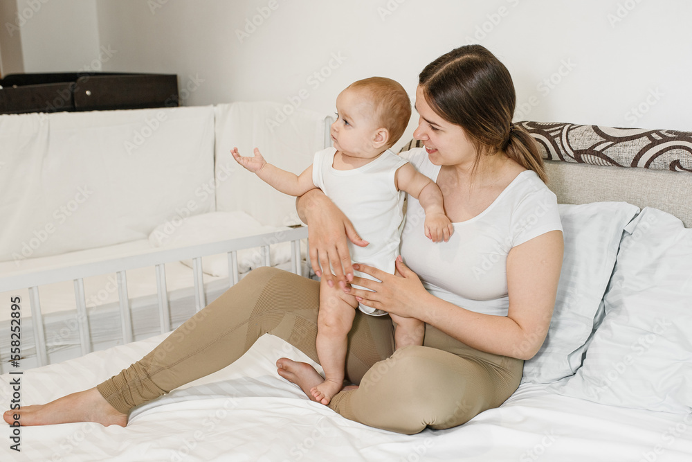 The baby shows something to his mother in the room. The baby shows something to his mother in the room.