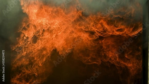 Big real fire of gas and oil explosion bursting through hot air. Car or building was burnt down.infernal fire in an industrial factory with big flame and smoke. Looping Fire Flames. Fire wall motion