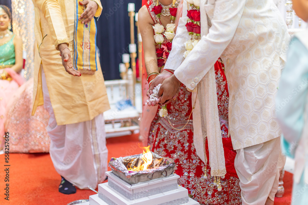 Indian Hindu wedding ceremony pooja ritual sacred fire and hands close up