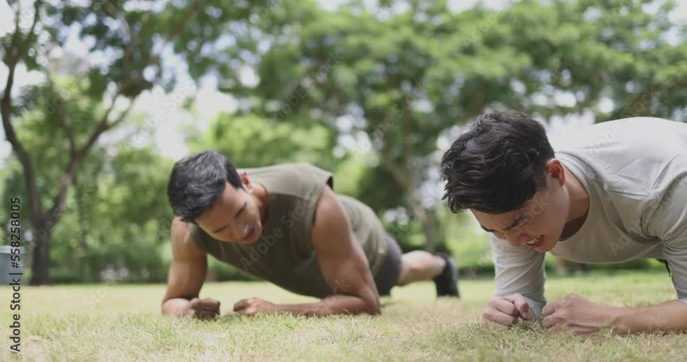 4K Video Asian young man planking together in green park. Concept for healthy lifestyle and outdoor life. 4K Video Asian young man planking together in green park. Concept for healthy lifestyle and outdoor life.