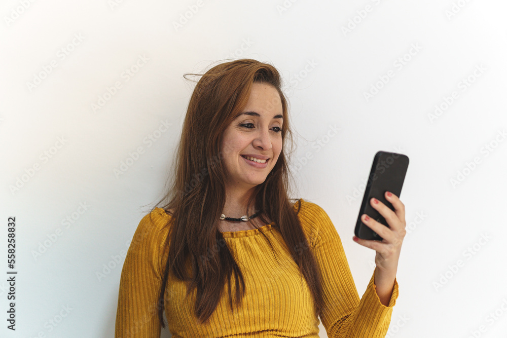 woman in yellow shirt on white background talking on mobile phone woman in yellow shirt on white background talking on mobile phone