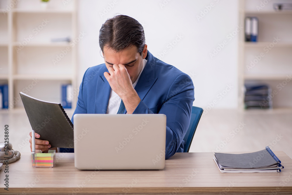 Young male employee working in the office Young male employee working in the office