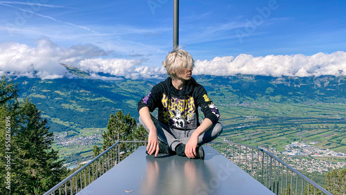 man with a mountainscape background, man with a mountain skyline background, man sitting cross-legged, guy with a mountainscape background, guy with a mountain skyline background 