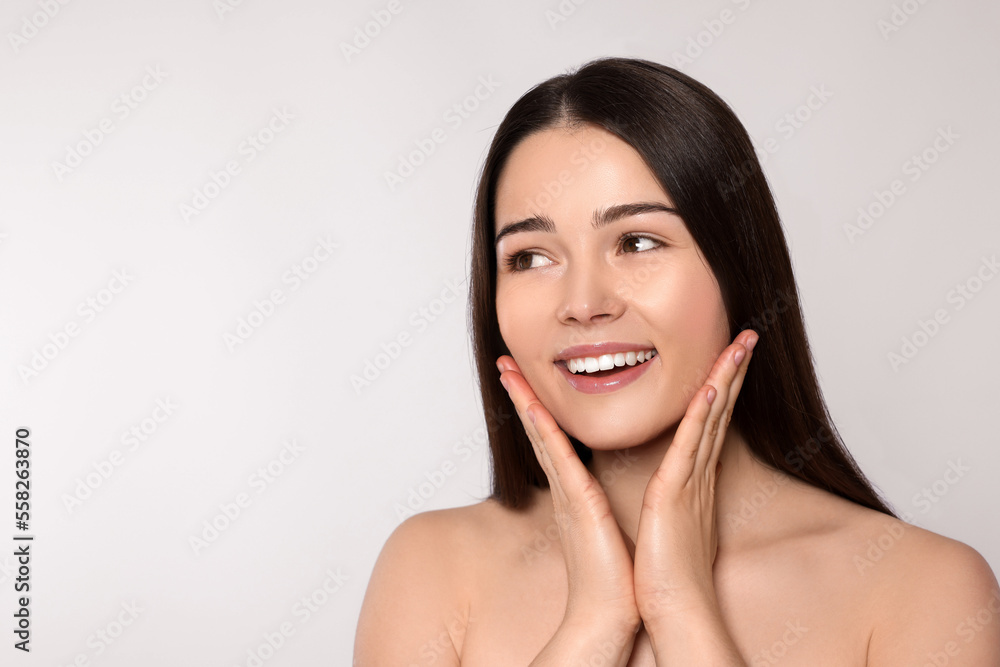 Portrait of attractive young woman on light grey background, space for text. Spa treatment Portrait of attractive young woman on light grey background, space for text. Spa treatment