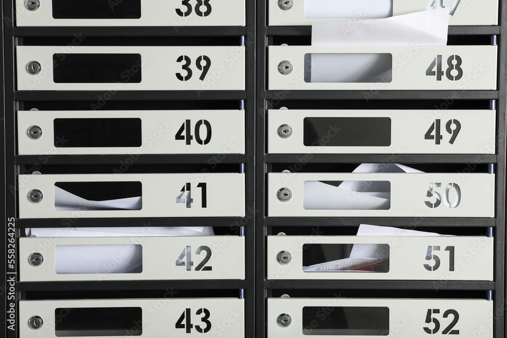 Metal mailboxes with keyholes, numbers and receipts as background Metal mailboxes with keyholes, numbers and receipts as background
