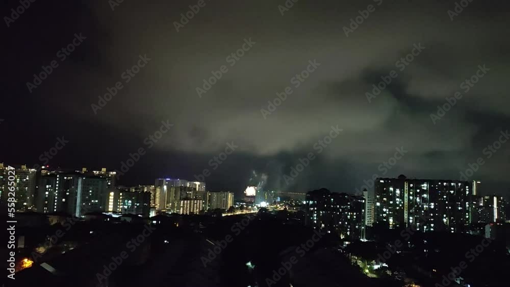 firework in asia city night with heavy white clouds in sky firework in asia city night with heavy white clouds in sky