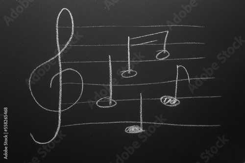 Treble clef and notes drawn with chalk on blackboard. Music Concept