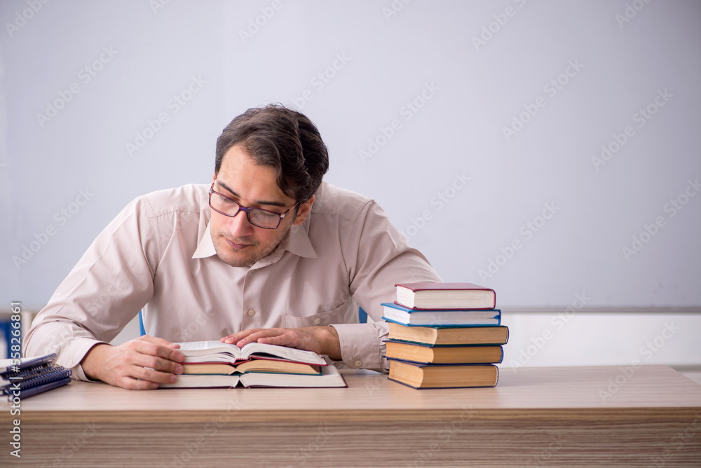 Young male teacher student sitting in the classroom Young male teacher student sitting in the classroom