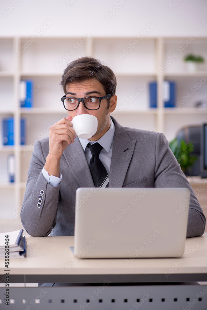 Young male employee and too much work in the office Young male employee and too much work in the office