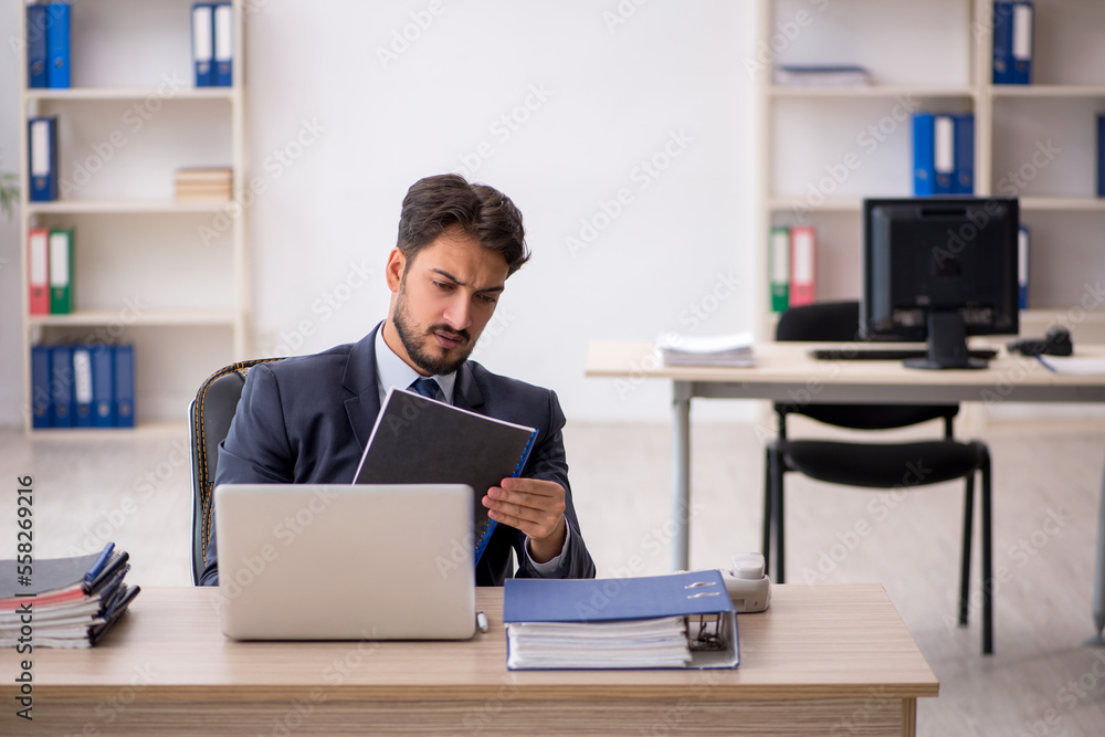 Young male employee working in the office Young male employee working in the office