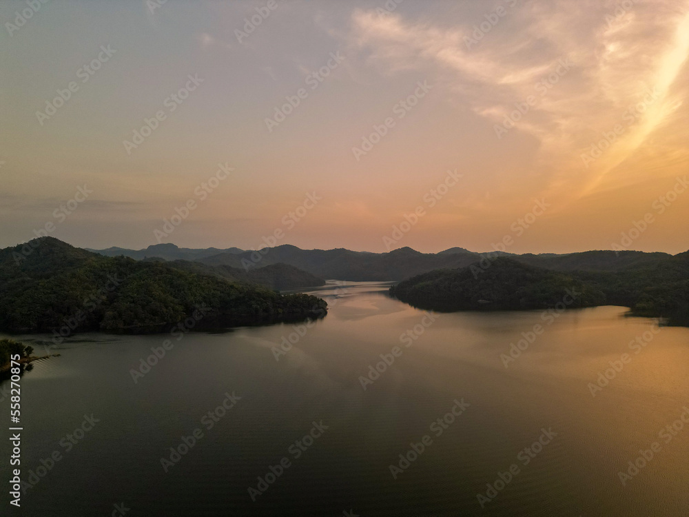 Backward aerial top view over winter mountain and woods forest at sunset or sunrise.Blue hour dusk or dawn twilight Alps mountains winter season establisher.4k drone flight establishing shot