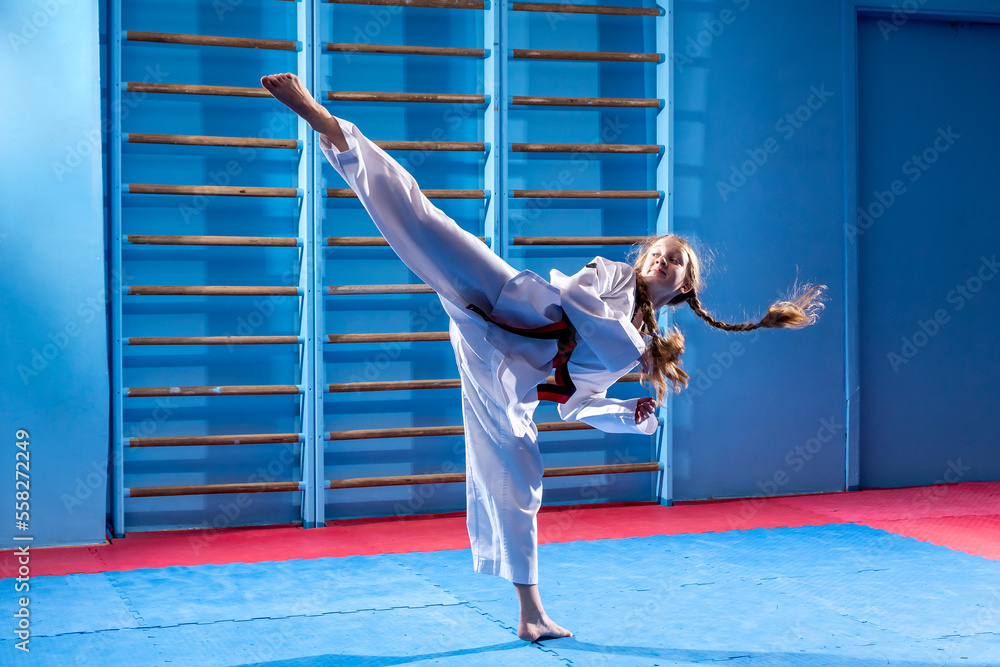 The karate woman with black belt. Sport woman fighting, poses punch in